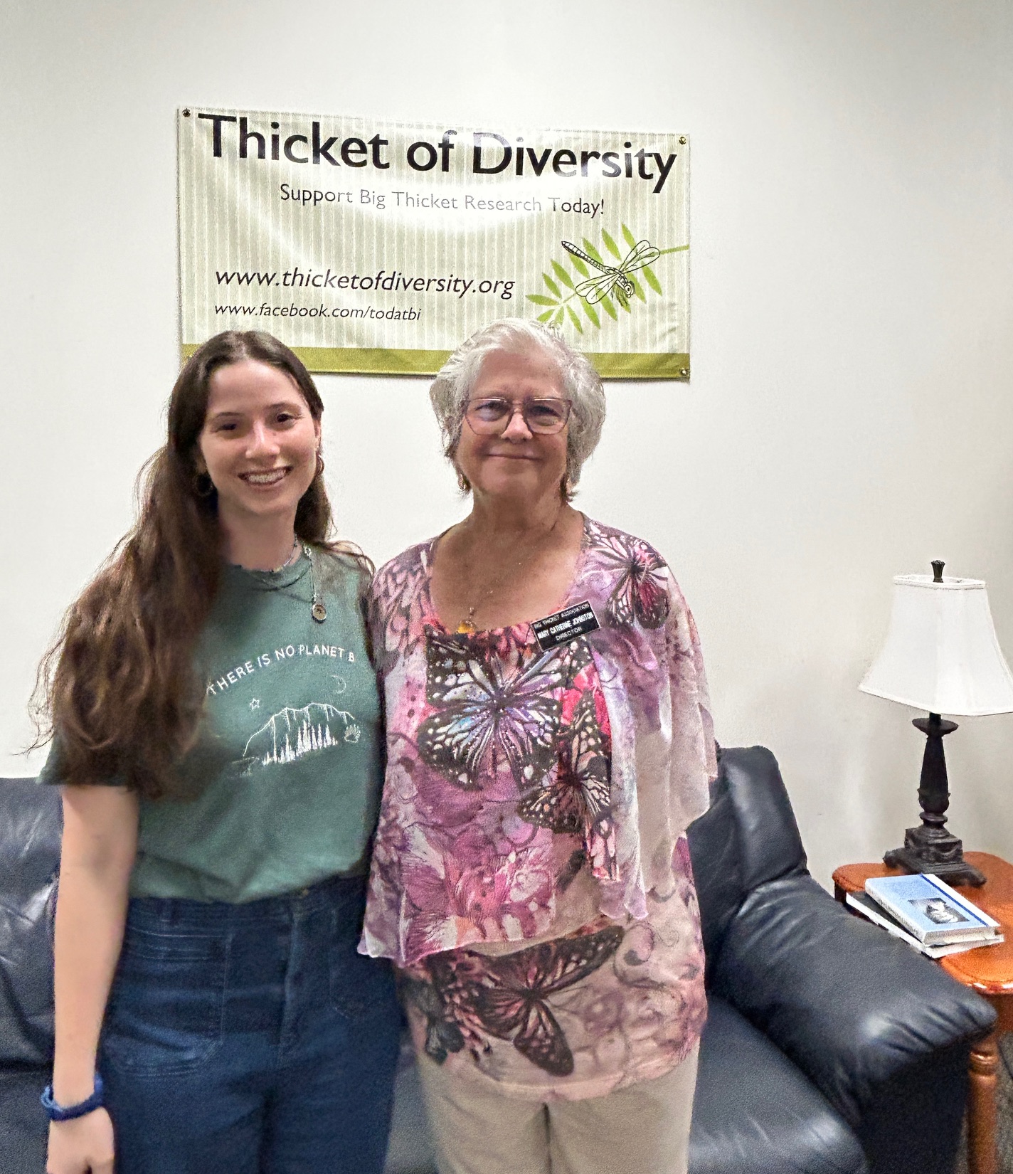 Natalia Doiron and Thicket of Diversity Chair Mary Catherine Johnston standing beneath a Thicket of Diversity sign.